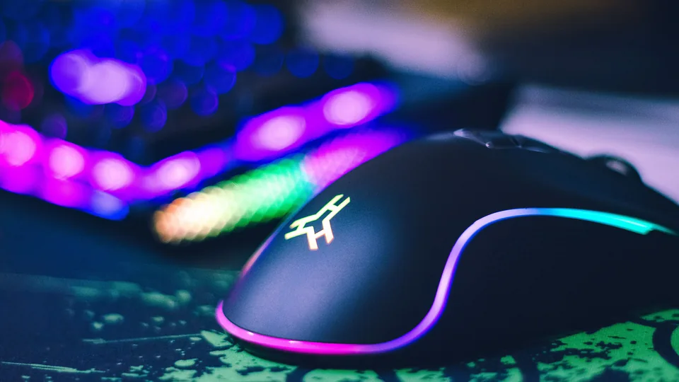 RGB gaming mouse beside an illuminated keyboard