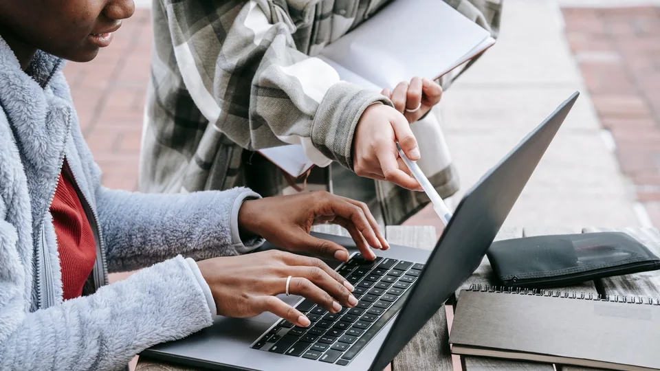 People working together with a laptop and notebooks
